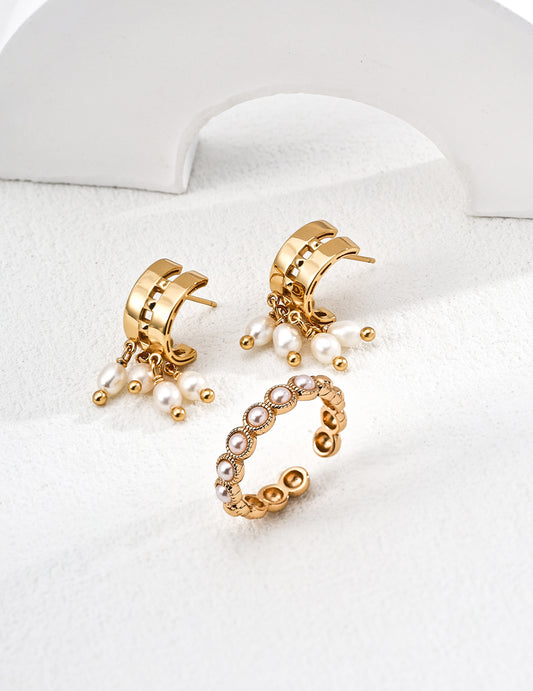 Elegant gold crescent-shaped hoop earrings with four hanging natural pearls, luxurious and refined design.