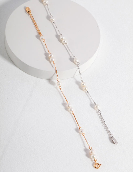 Charming bracelet with alternating gold and silver chains, featuring nine small pearls in a distinctive arrangement, perfect for adding subtle elegance to any outfit